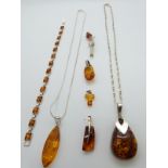 A collection of silver and pressed amber jewellery including bracelet, three pendants and brooch