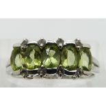 A 9ct white gold ring set with peridot and diamonds, size N