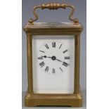 Early to mid twentieth century brass carriage clock in corniche style case, the white enamel dial