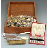 A large collection of silver plated cutlery, cased set brushes etc