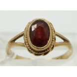A 9ct gold ring set with a garnet, size K