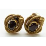 A pair of Victorian earrings set with foiled garnets surrounded by snakes with textured detail