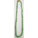 A jade necklace made up of spherical graduated beads, with  filigree clasp length 50cm
