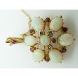An 18ct gold pendant/ brooch set with seven opal cabochons, rubies and diamonds