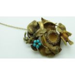 Victorian brooch in the form of a snake wrapped around a bird's nest amongst foliage, with