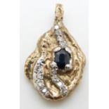 A yellow metal bi-coloured nugget style pendant set with an oval cut sapphire and diamonds, 13.1g