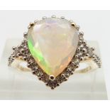 A 9ct gold ring set with a pear cut opal surrounded by white sapphires, size N