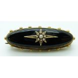 Victorian brooch set with onyx and seed pearls to the centre in a star setting