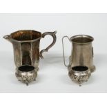 A pair of Indian/Burmese white metal salts with embossed decoration of animals in foliage, jug