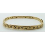 A 9ct gold bangle set with diamonds in star settings,17.1g