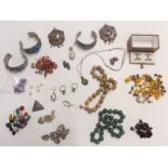 A collection of jewellery including white metal bangles, beads, silver ring, silver pendant, agate