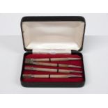 Cased set of four white metal propelling whist pencils, each with suit to top and marked sterling