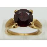 A 14ct gold ring set with a round cut garnet, size I