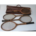 Four vintage tennis rackets and a leather carry case.