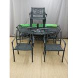 A cast aluminium garden table, diameter 152cm, with six chairs and cushions and matching umbrella