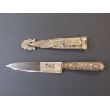 A knife in sheath impressed Tandril Argentina, with relief moulded decoration. Blade length 14cm.