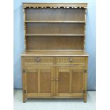 Oak dresser with carved decoration and plate rack above, W125 x D48 x H182cm