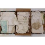 A large collection of linen and lace including several tablecloths, some unused