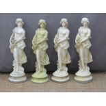 A set of four garden statues of ladies with flowers, height 65cm