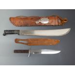 A machete in decorated leather sheath. Blade length 46cm together with bowie knife in leather