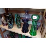 A collection of coloured glass vases; together with five pottery fish jugs.