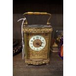 An Edwardian brass carriage timepiece, height including handle 15.5cm, with winding key.