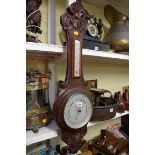 A carved walnut aneroid banjo barometer.