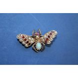 An opal, ruby and seed pearl set butterfly, mounted in yellow metal.