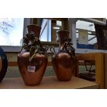 A pair of brass and copper twin handled vases, 26.5cm high.