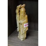 An Oriental carved soapstone figure, 20cm high.