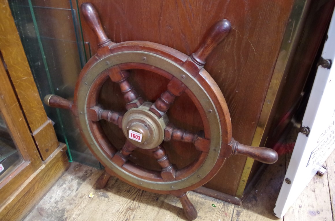 An old teak and brass ships wheel, 61cm diameter.