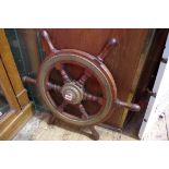 An old teak and brass ships wheel, 61cm diameter.