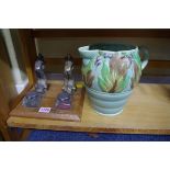 A dolphin form desk stand; together with a Clarice Cliff 'Autumn Leaves' jug, (a.f.).