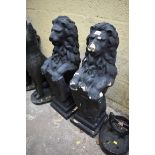 A pair of black painted composition stone heraldic lions, 82cm high.