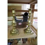 An old flat iron; together with a pair of Victorian brass candlesticks.