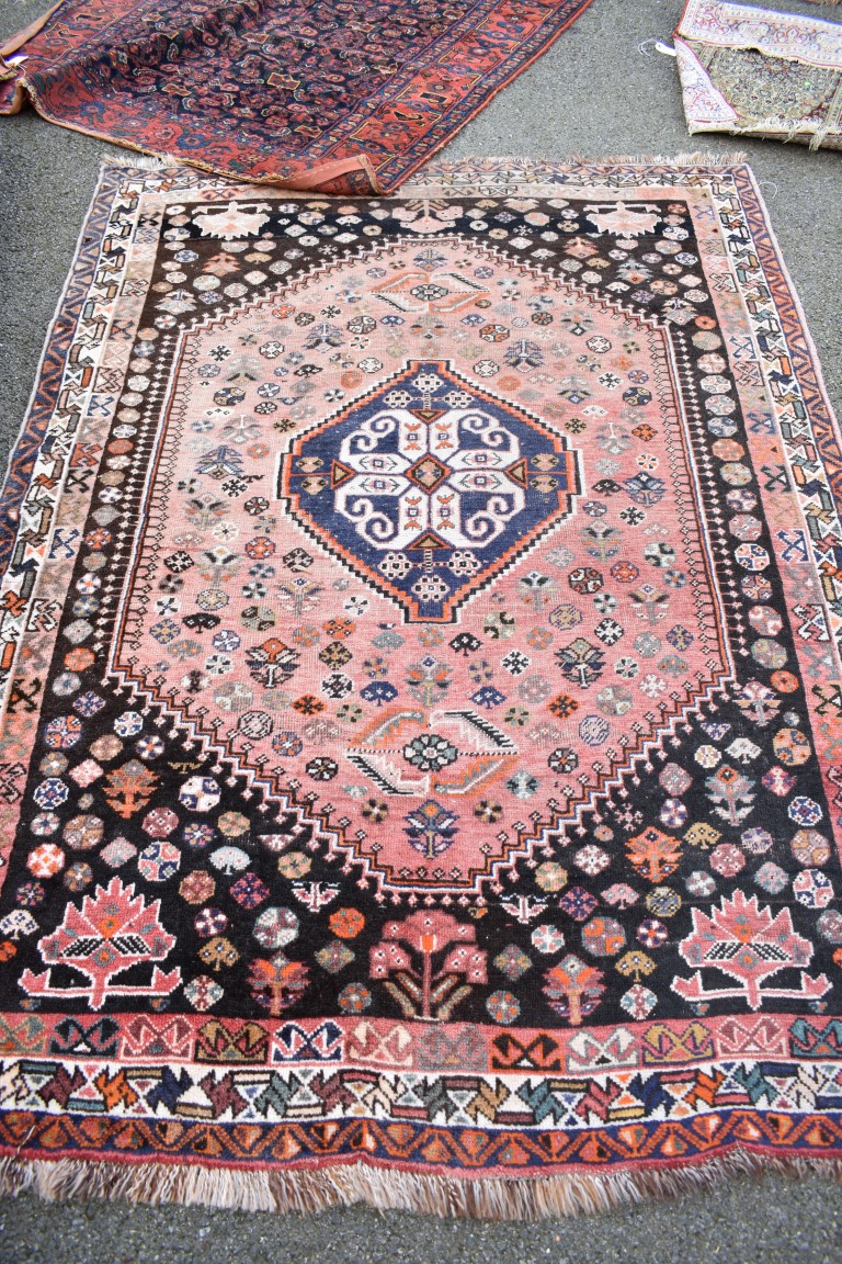 An Eastern wool rug having geometric design on red and brown ground;