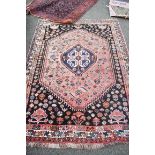 An Eastern wool rug having geometric design on red and brown ground;
