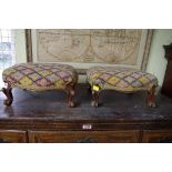 A pair of walnut and upholstered footstools.