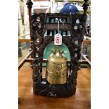 A Chinese bronze temple bell, in carved hardwood and metal wire inlaid stand, 36.5cm high.