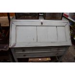 An antique French painted pine bureau, having two short and one long drawer, 99cm wide.