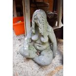 An old weathered composition stone seated nude, 45cm high.