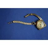 A 9ct gold ladies wristwatch having chased dial, on plated bracelet.