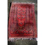 A Bokhara rug, on red ground having floral borders.