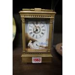 A brass and porcelain carriage clock, decorated with female nudes, with alarm and bell strike,