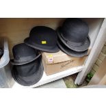 Five various bowler hats; together with a top hat.