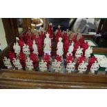A Chinese carved ivory chess set, Qing, red stained and natural, each with puzzle ball base, king