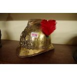 An antique French brass firemans helmet, inscribed 'Sapeurs Pompiers... Lyon'.