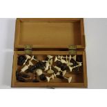 A bone travelling chess set, in folding chequer board box, 15.5cm wide, (incomplete).