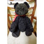 A vintage Austrian black astrakan teddy bear, approx. 20cm long.