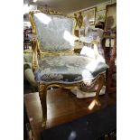 A Louis XV style carved giltwood and silk damask fauteuil.